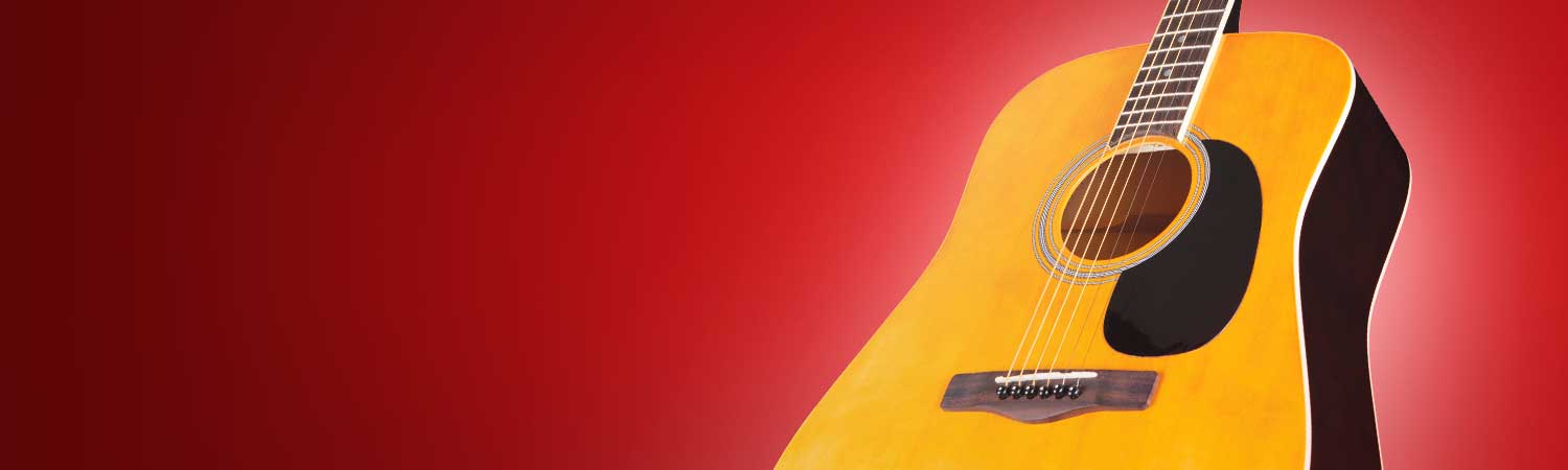 Acoustic tan guitar against a red background
