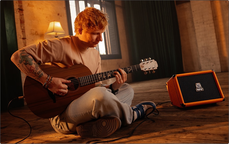 Ed Sheeran playing guitar with Orange amplifier.